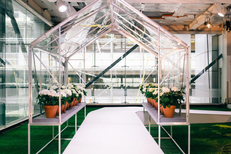 single greenhouse sheltering white catwalk for hunter boots event